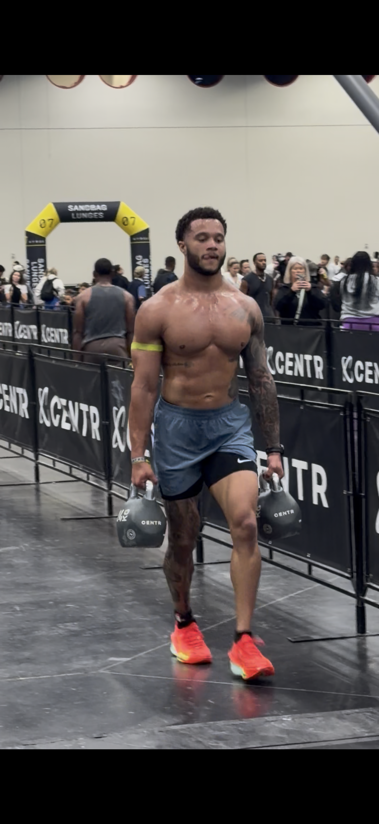 Asantay Brown carrying kettlebells at a HYROX competition